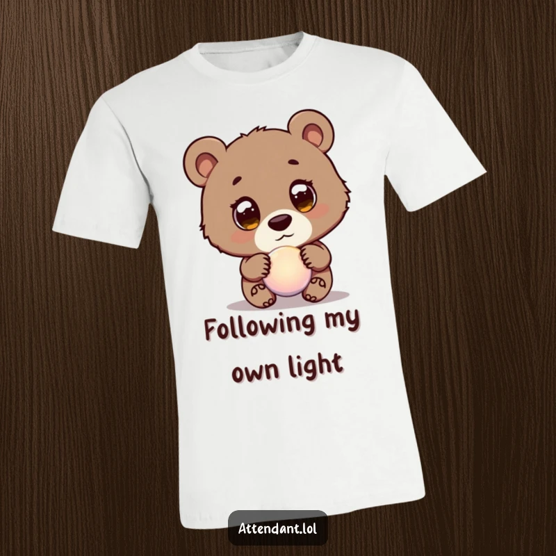 Funny Bear Cub T-Shirt: A wide-eyed, curious bear cub gently leads a glowing orb, a humorous and endearing design.